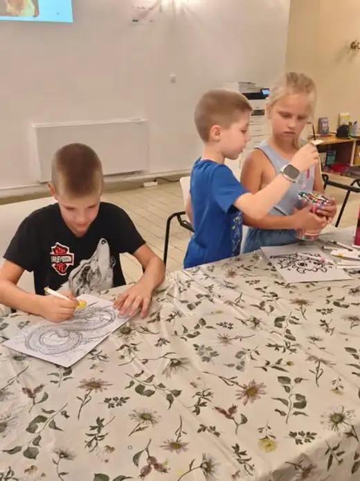 Момче оцветява картинка на вълшебно същество на масата