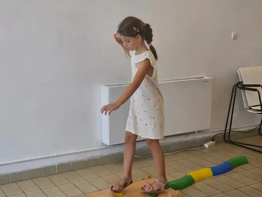 Момиче балансира по дунапренова греда.