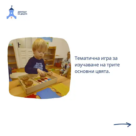 Момченце подрежда кошнички с цветни капачки в дървена табла на маса, отзад друго дете и жена на пода.